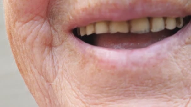 웃 고 yellowed 이빨을 보여주는 할머니의 입을 닫습니다. 카메라에 웃음 주름이 피부와 고위 여자입니다. 슬로우 모션 — 비디오