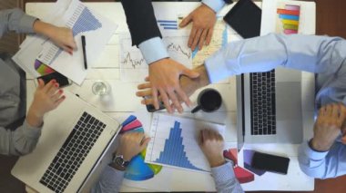 Başarı kutlayan dört iş adamının üst görüntüsü. Bir grup işveren neşe içinde tek tek kollarını birleştirdi. Modern ofiste çalışan yaratıcı ekip. Başarı konsepti