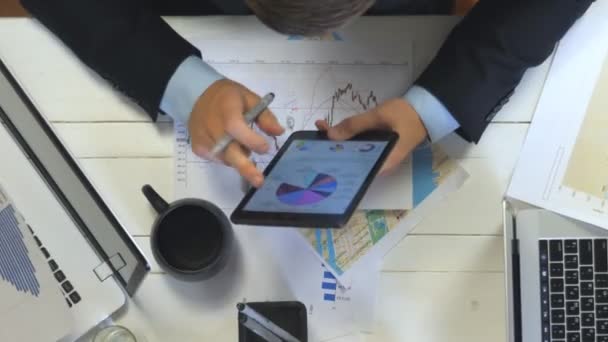 Laptopları ve grafikleri kullanarak verimli çalışan iş adamlarının üst görüntüsü. Moda ofisindeki masada oturan bir grup genç işçi. Yaratıcı ekip geliştirme işiyle meşgul. Yavaş çekim — Stok video