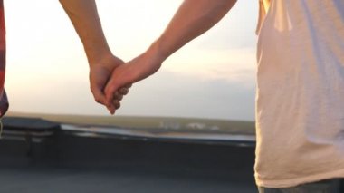 Kamera akşam saat takip çatı ve tutuşup birbirlerinin gay çift çalışır. Birlikte vakit aşık açık. Erkek ilişkileri kavramı. Arka arkadan görünüm yavaş hareket yakın çekim