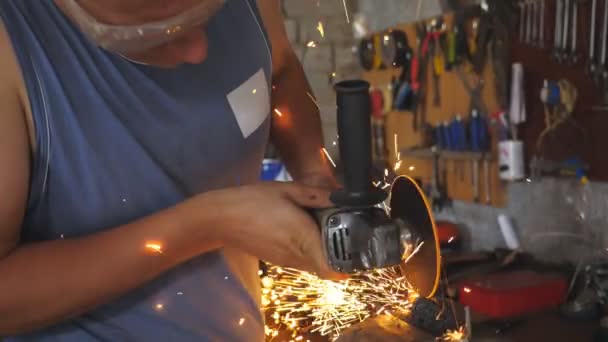 Réparateur professionnel ou ouvrier mécanicien sciant le métal avec une scie circulaire dans le garage. Soudeur adulte coupant l'acier à l'aide d'une meule électrique et de lunettes de protection en atelier. Mouvement lent — Video
