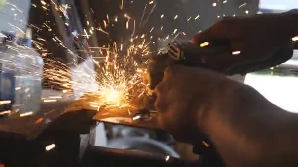 ワークショップで電気研磨ホイールを使用して、男性溶接機切削鋼の男性の手。プロの修理工やメカニック労働者の腕ガレージで円形のこぎりで金属を鋸で。サイドビュークローズアップ — ストック動画