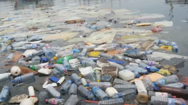 Milieuvervuiling. Plastic flessen, tassen, afval in de rivier, het meer. Vuilnis en vervuiling drijvend in water — Stockvideo