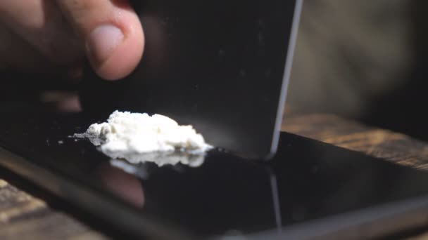 Kredi kartı tutan ve telefon ekranında kokain hattı yapan bağımlının elini yakın. Uyuşturucu satıcısının erkek kolu, yasadışı uyuşturucuyu akıllı telefona bölüştürdü. Bağımlılık ve madde bağımlılığı kavramı. Yavaş mo — Stok video