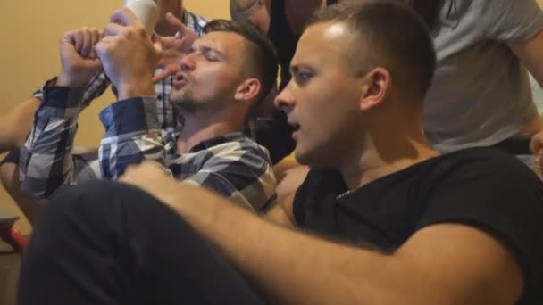Happy best friends celebrating victory for their favorite team. Group of emotional people watching sports game on laptop at home. Young football supporters scream with arms raised. Slow motion — Stock Video