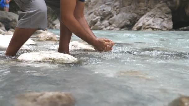 Homem irreconhecível lavando as mãos no rio da montanha com água fria clara. Cara entre o rio com fluxo rápido e refrescante. Caminhante masculino durante sua viagem. Lento mo Visão inferior Close up — Vídeo de Stock