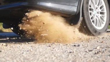 Hareket başladığında arabanın tekerleği asfalt yolda kayıyor. Küçük taşlar ve toprak bir otomobilin lastiğinin altından uçar. Araç hareket etmeye başlıyor. Bitkinlik kavramı. Yavaş çekim