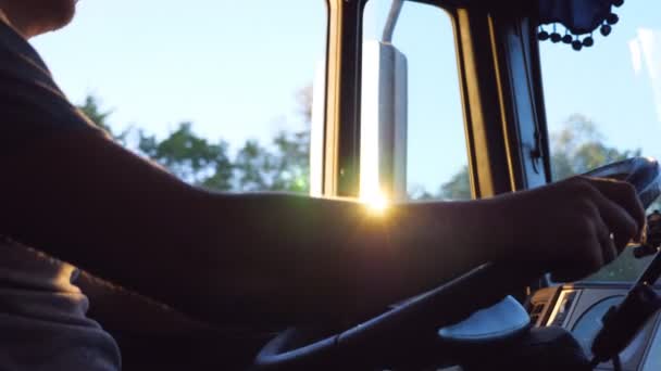 Onherkenbaar man met zijn handen op het stuurwiel en het besturen van een vrachtwagen op landweg op warme zomerdag. In de cabine van de truck. Zijaanzicht Slow Motion close up — Stockvideo