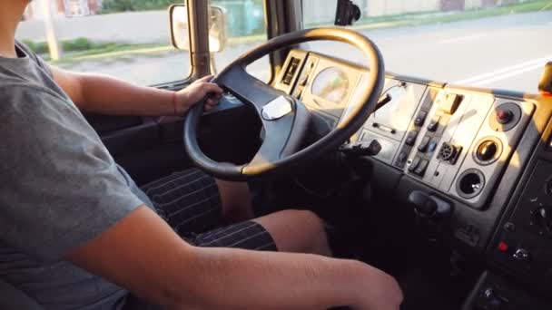 Oigenkännlig man håller sin hand på ratten och köra lastbil på Urban Road. Arm av Trucker på Wheel of Car. Lastbilschaufför åker till destinationen. Utsikt inifrån bil hytten. Slow motion — Stockvideo