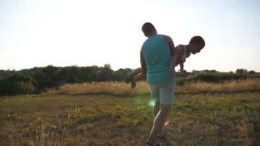 Mutlu baba kucağında ve elinde onun küçük çocuğu döndürür. Kızıl saçlı çocuk uçak gibi uçtuğunu hayal ediyor. Neşeli baba ve oğul güneşli bir günde çayırda oynuyorlar. Aile birlikte dışarıda vakit geçiriyor