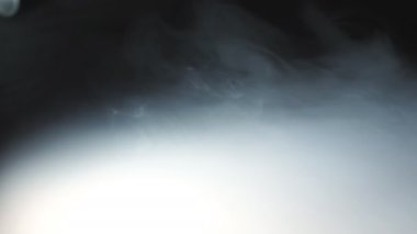 Masanın yüzeyinde yayılan vape gelen ağır beyaz duman düşük görünümü. Ahşap masa üzerinde kapsayan bir elektronik sigara veya nargile süt buhar Saf kulüp. Siyah arka plan. Yakın çekim