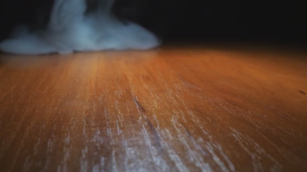 Humo blanco pesado del vapor que aparece en la superficie de la mesa. Hermoso club de vapor de leche de un cigarrillo electrónico o narguile que se extiende en el escritorio de madera. Fondo negro. Vista baja Primer plano — Vídeos de Stock