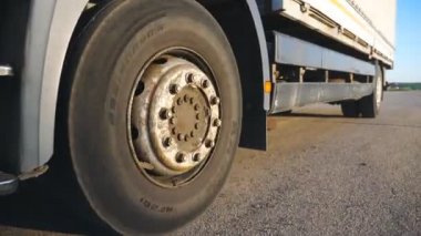 Kırsal boyunca asfalt yolda sürme kamyon büyük tekerlek kapatın. Kamyon karayolu boyunca hız hedefe sürme. Akşam saatlerinde büyük kamyon malları. Ulaşım ve lojistik konsepti. Yavaş çekim