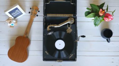 Beyaz ahşap masada eski oyun gramofon üzerinde üst görünümü. Vinil kayıt vintage pikap üzerinde dönen. Retro konsepti. Yukarıda çekim Yavaş hareket Kapat