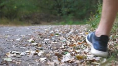 Sonbahar ın başlarında ki ormanda patikaboyunca koşan genç atletin erkek ayakları. Doğada yol boyunca koşan sportif bir adamın bacakları. Dışarıda ki sporcu antrenmanLarını takip edin. Sağlıklı aktif yaşam tarzı. Arka görüş