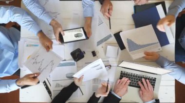 Ofiste kurumsal proje için strateji planlama iş adamlarının üst görünüm erkek ve kadın elleri. İş ekibi masada oturuyor ve finansal grafikleri kontrol ediyor. Masa başında belgeleri inceleyen iş arkadaşları