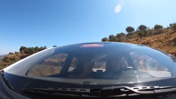 Vista desde el parabrisas hasta dos parejas jóvenes que viajan en coche juntas. Hombres y mujeres sentados en automóvil durante el viaje por carretera. Amigos conduciendo por auto en vacaciones de verano. Concepto de viaje. Cronograma — Vídeo de stock