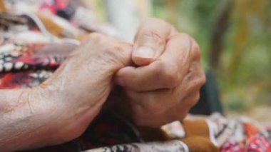 Büyükanne dışarıda kırışıklık ellerine masaj yapıyor. Yaşlı kadın kollarını dışarıda halletti. Yukarı yakın Yan görünüm Yavaş çekim