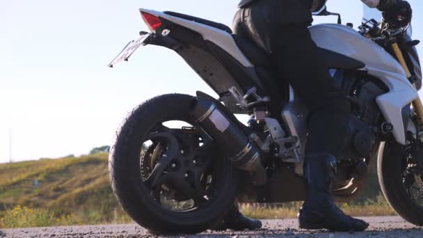 Rueda de moto deportiva que comienza a girar en asfalto y patear guijarros y suciedad. Motociclista realizando agotamiento de neumáticos con mucho humo. La motocicleta inicia el movimiento. Cámara lenta Primer plano — Vídeo de stock