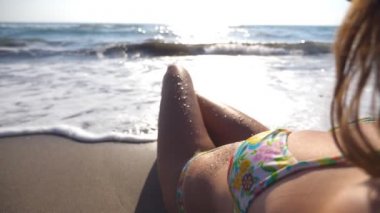 Seksi kız sahilde dalgaların yalan. Güzel ve genç birbayan rahatlatıcı yaz tatil seyahat sırasında deniz kıyısında. Okyanus dalgaları üzerinden yıkama kadın cesedi bronzlaşmış. Ağır çekim yakın çekim
