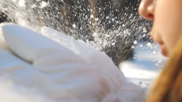 Femme méconnaissable dans des gants blancs soufflant de la neige de ses paumes. Jeune fille debout au milieu de la forêt d'hiver et jouer avec la neige lors d'une journée ensoleillée. Fond flou. Concept d'hiver Slow mo Vue détaillée — Video