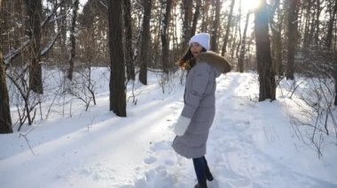 Young couple having snowball fight during stroll through snowy forest. Funny girl throwing snowball to his unrecognizable boyfriend and running away. Concept of winter holiday. Slow motion Close up