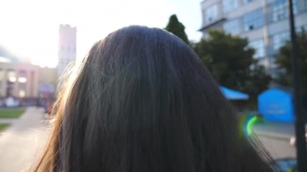 認識できない女性は早朝の通りで働くと矯正髪に行く。かなりの女の子が仕事に向かう途中で街を散歩していた。魅力的なブルネットの日光輝く髪。スローモ — ストック動画