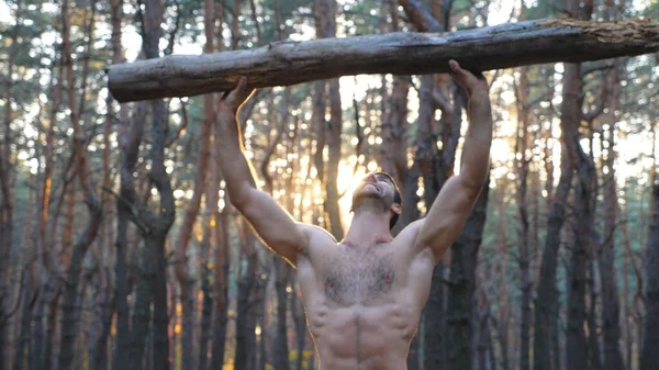肌肉男子举重超过头部训练的手 强壮的人赤身裸体在森林里锻炼运动员在美丽的自然环境中运动 运动和积极的生活方式 Dolly Shot — 图库照片