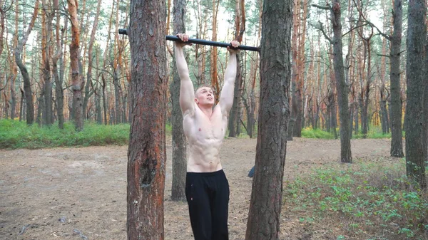 Atletische Man Training Buikspieren Verhogen Benen Horizontale Balk Een Spierbundel — Stockfoto