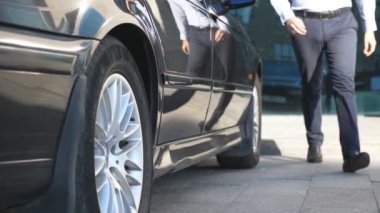 Sürücü arabaya geliyor ve iş adamına kapıyı açıyor. Şoför, erkek yolcular için otomobilin kapısını açtı. İşadamı arabadan indi ve ofis binasına gitti. Yavaş Hareket