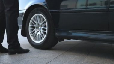 İş adamı arabaya geliyor ve genç bir bayana kapıyı açıyor. Erkek, kadın yolcu için otomobilin kapısını açar. İş kadını arabadan indi ve iş arkadaşıyla birlikte ofis binasına gitti.