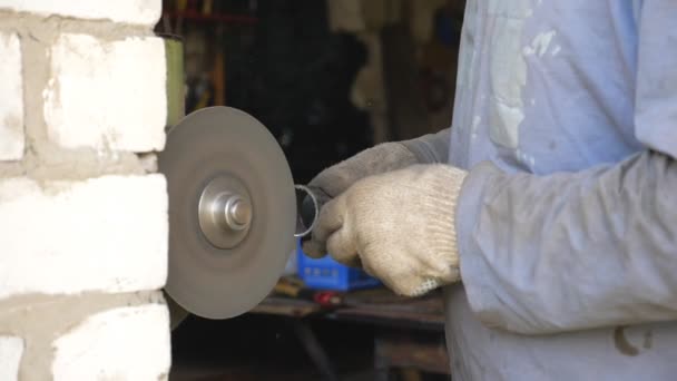 Manos de mecánico sosteniendo el detalle de metal y afilándolo en la piedra de afilar. Hombre trabajando en garaje o taller. Reparador moliendo parte de hierro. Trabajador que usa guantes por seguridad. Cámara lenta Primer plano — Vídeos de Stock