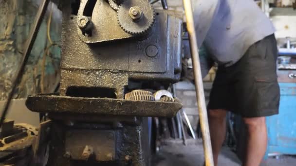 Homem adulto trabalhando com bancada em sua garagem ou oficina. Mecânico ou torneador usando torno para processamento de metal. Ver como virar o trabalho. Movimento lento — Vídeo de Stock