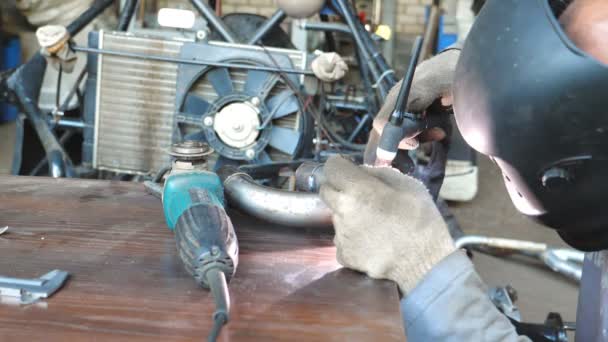 Mécanicien avec masque de protection soudage détails de l'automobile. Repairer réparation automobile. Homme travaillant dans le garage avec une machine à souder et d'autres équipements. Auto maître engager voiture d'entretien. Fermer Vue latérale — Video