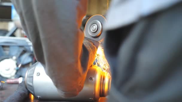 円形ののこぎりで金属加工を表示します。機械保持器と研削自動車の詳細の手。男はガレージやワークショップでサービス車に従事します。明るい熱い火花が飛び回る — ストック動画