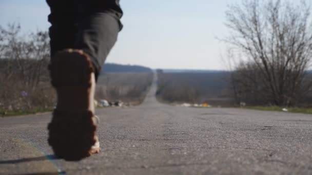 バックパックを持つ小さな女の子の訓練に道路の間を歩く。ジャケットの女性の子供は学校へのドライブウェイに沿って行きます。認識できない小さな子供は晴れた日に移動します。"燃えるような動き"。クレーンショットスローモ — ストック動画