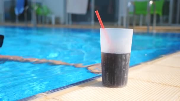 Cerrar vaso de cóctel fresco de pie cerca de la piscina. Chica nadar en el borde de la cuenca para refrescarse con bebida fría. Mujer atractiva que se relaja en el complejo de lujo con bebidas alcohólicas frías. Movimiento lento — Vídeos de Stock