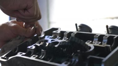 Erkek eller araba motorunu tamir ediyor. Otomatik araç kullanan bir adam var. Tamirci garajda ya da atölyede çalışıyor. Yavaş çekim. Yakın çekim.