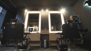 Berber dükkanındaki boş salondan geçen kamera. Modern moda kuaför salonu manzarası. Moda mobilyalı şık bir güzellik salonu tasarımı. Kuaförün işyeri. Yavaş çekim