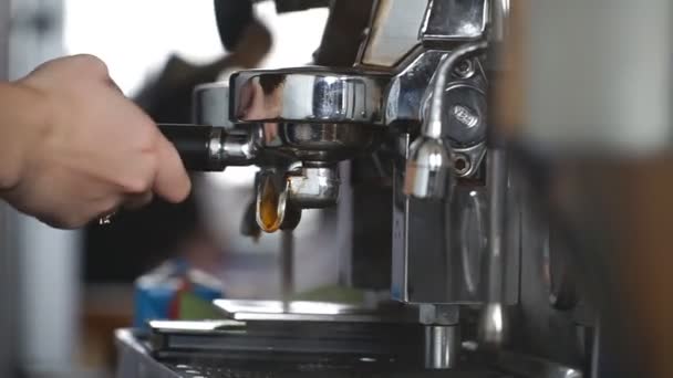 전문적 인 커피 기계로 천연 강한 커피 를 준비하는 것을 고려하라. 여성 바리스타가 필터 홀더를 사용하여 신선 한 향긋 한 음료를 만듭니다. 도시의 카페에서 일하고 있습니다. 슬로우 모션닫기 — 비디오