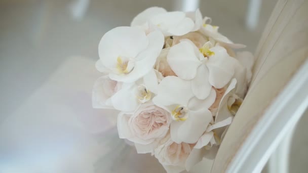 Detailní záběr svatební kytice s jemnými růžovými květy. Elegantní krásné svatební šaty. Svatební symbol. Detailní pohled na hromadu růží a orchidejí. Zpomalený pohyb