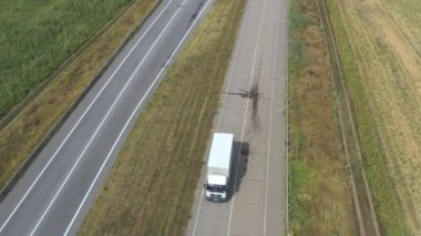 Boş yolda giden ve malları taşıyan kargo karavanlı bir kamyonet görüntüsü. Taşra otobanı boyunca giden teslimat kamyonunun üzerinde uçuyor. Kargo taşıma konsepti. Yavaş çekim Üst Görünüm