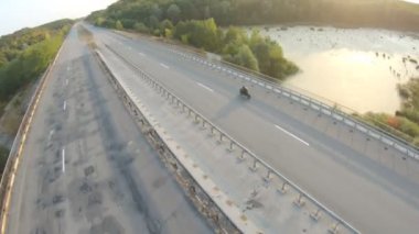 Yaz seyahati sırasında otoyolda motosiklet süren bir adamın havadan görünüşü. Motosikletli, kır yolunda motosikletiyle yarışıyor. Yolculuk sırasında bisiklet süren adam. Özgürlük ve macera kavramı