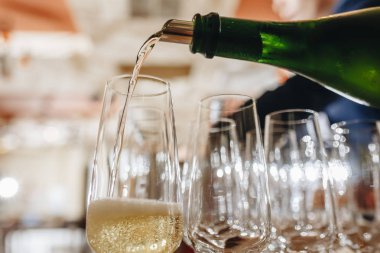 Restoranda masada bir bardak içine bir şişe şampanya Sommelier dökülen