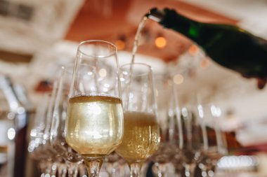 Restoranda masada bir bardak içine bir şişe şampanya Sommelier dökülen