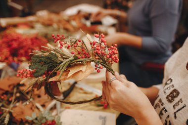 Kadının elleri birbirine yakın. Çiğ kil ile çalışın. Kil bardak ve tabak. Ahşap tahta üzerinde mutfak eşyaları