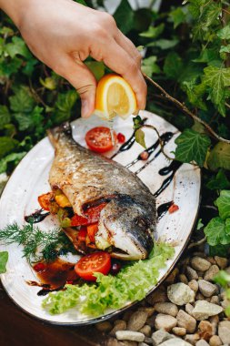 ızgara Dorado sebze kadın el garson limon suyu döker ile doldurulmuş