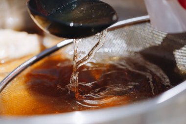 bir kepçe bir elek ile bir tencerede taze suyu