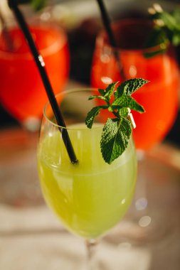 Şarap kadehinde yaz kokteyli. Nane yaprakları, cin tonik, syrop ile ferahlatıcı içecek. Ahşap arka plan. Şarap kadehinde yaz kokteyli. Serinletici