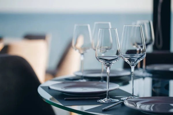 Vasos, tenedor de flores, cuchillo servido para la cena en el restaurante con interior acogedor —  Fotos de Stock